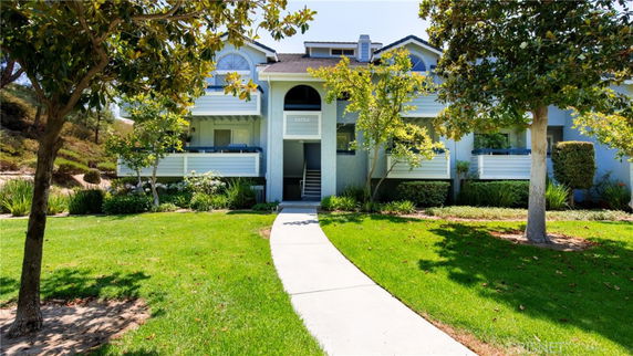 Front view of a two-story house with balconies and a central entrance.