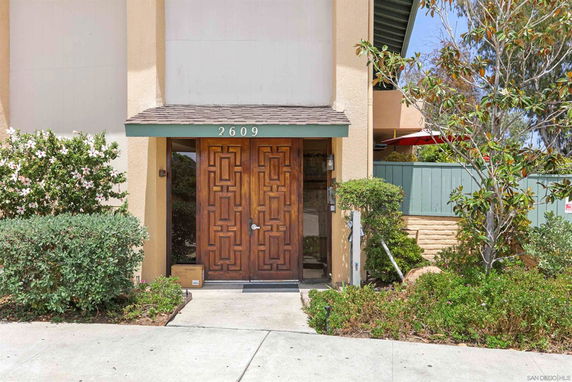 Front view of a house with a wooden double door entrance.