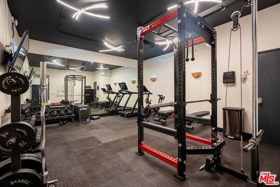 Indoor gym area with fitness equipment and mirrors.