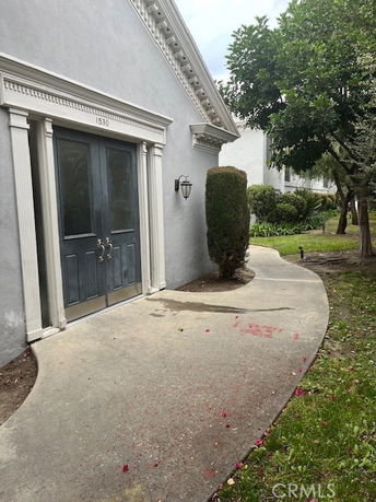 Front view of a building with double doors and a pathway leading up to it.