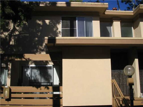 Front view of a two-story building with large windows and a balcony.