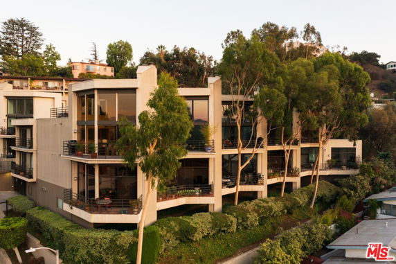 Front view of a modern multi-story building with large windows and balconies.