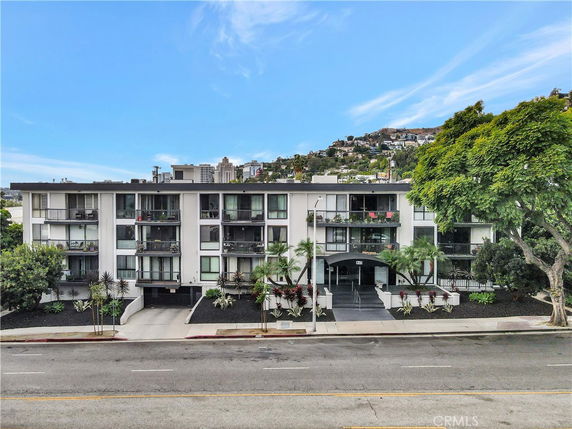 Front view of a multi-story apartment building with balconies.