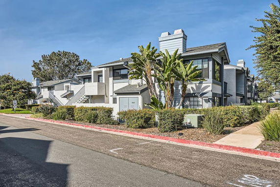 Front view of a two-story residential building with modern design and outdoor landscaping.
