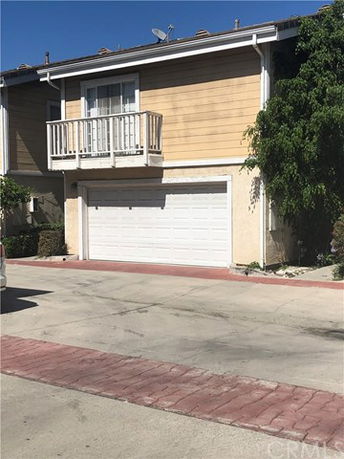 Front view of a house with a double garage and balcony.