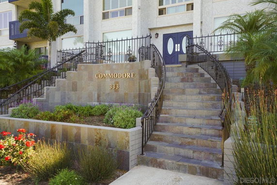Front view of a building with stairs and decorative railings leading to the entrance.