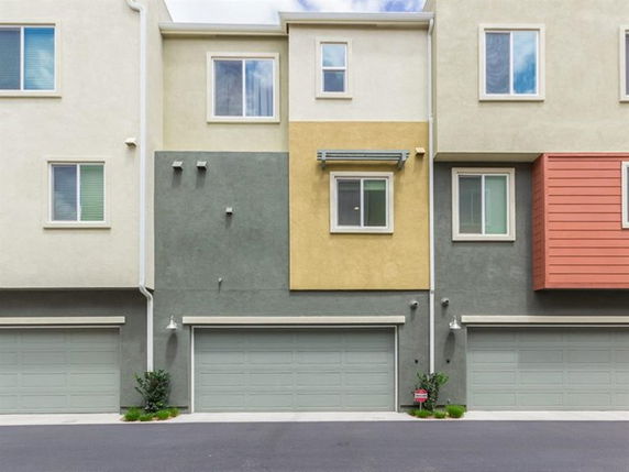 Front view of a multi-story residential building with garages.