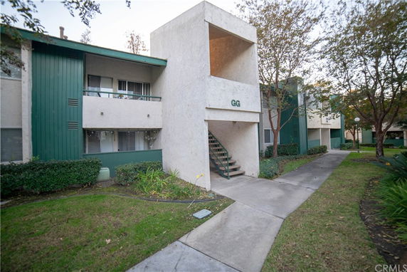 Front view of an apartment building with green and beige exterior.