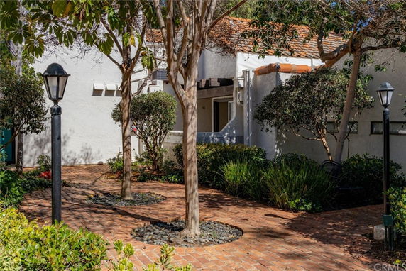 Front view of a building with a brick pathway and shrubs.