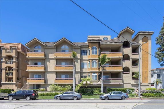 Front view of a multi-story apartment building with balconies.