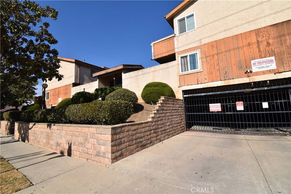 Front view of a multi-story building with a gated entrance.