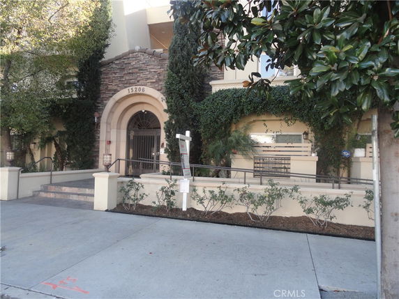 Front view of a building with stone accents and greenery.