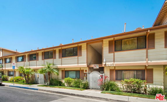 Front view of a two-story residential building with gated entry.