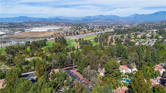 Panoramic view of a residential area with trees and mountains in the background.