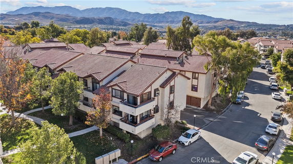Aerial view of residential buildings with red-tiled roofs and multiple units.