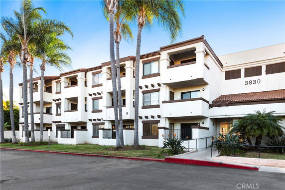 Front view of a three-story apartment building with balconies.