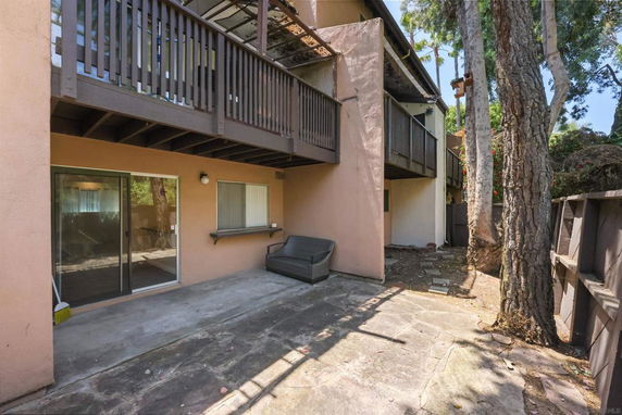 View of a multi-story building with wooden balconies and sliding glass doors.