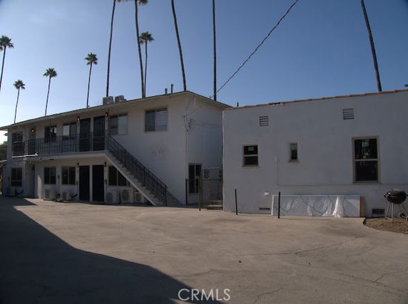 View of a two-story building with an external staircase and multiple units.