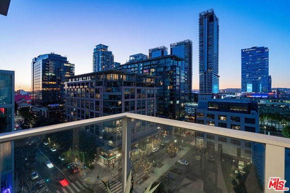 Panoramic view of a cityscape with multiple high-rise buildings seen from a balcony.