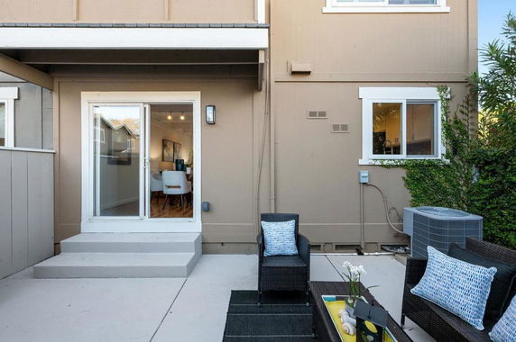 Rear view of a two-story house with patio seating area.