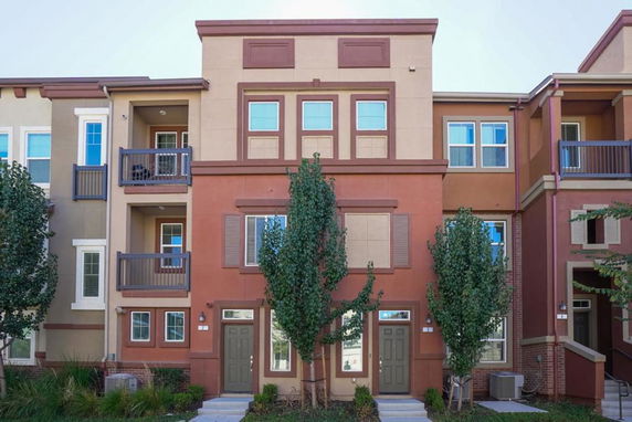 Front view of a multi-story building with balconies and trees