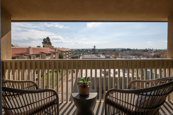 View from a balcony showing residential buildings and distant surroundings.