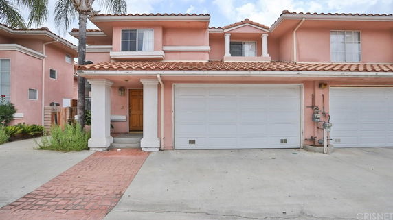 Front view of a two-story house with pink exterior and a double garage.