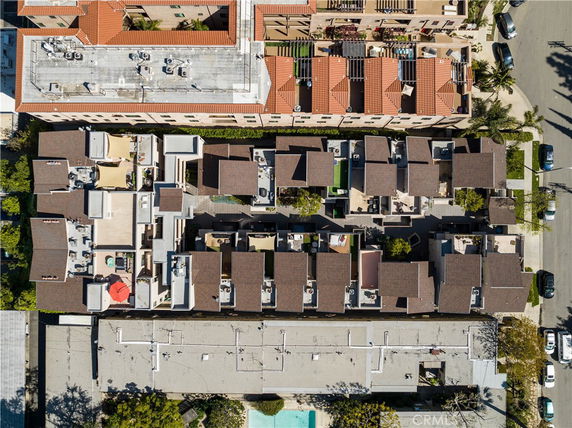 Aerial view of a residential complex with flat rooftops, featuring several air conditioning units and solar panels.