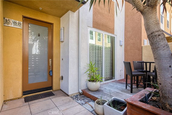 Front view of a modern house entrance with glass door and patio area.
