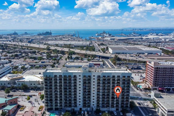Aerial view of a building with a cityscape and waterways in the background.