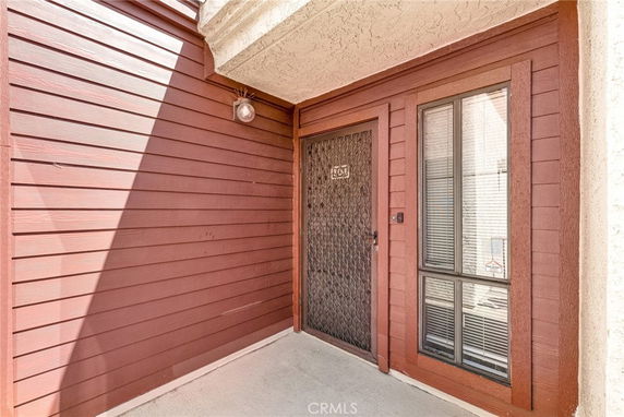 Entryway of a building with a red door and adjacent window.