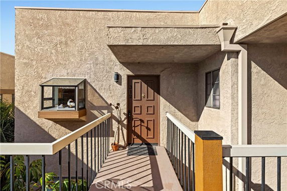 Entrance of a building with a walkway leading to a wooden door on the upper level.