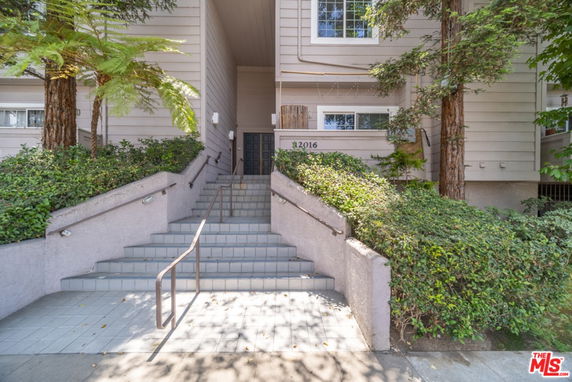 Front view of a building with stairs leading to the entrance.