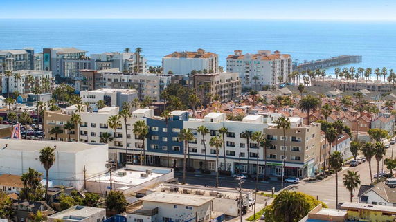 Panoramic view of a coastal city with multiple mid-rise buildings near the ocean.