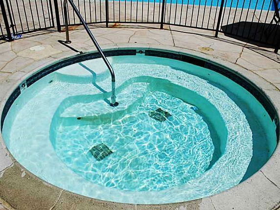 Outdoor circular swimming pool with railings.