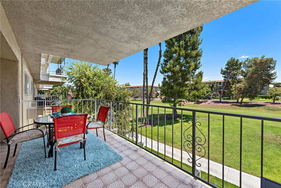 Balcony view overlooking a grassy area with trees.