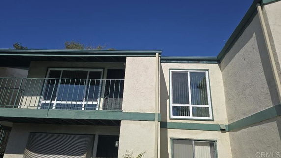 Front view of a two-story building with balconies and large windows.
