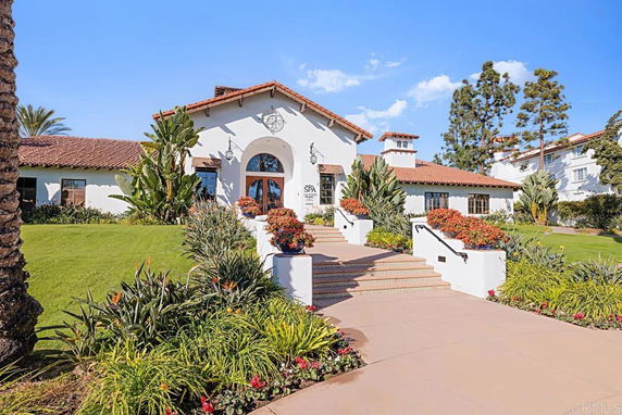 Front view of a large, single-story house with a Spanish-style roof and landscaped entrance.