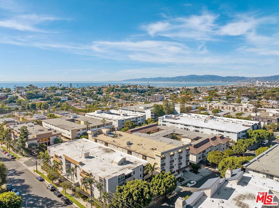Panoramic view of a cityscape with multiple buildings and a distant coastline.