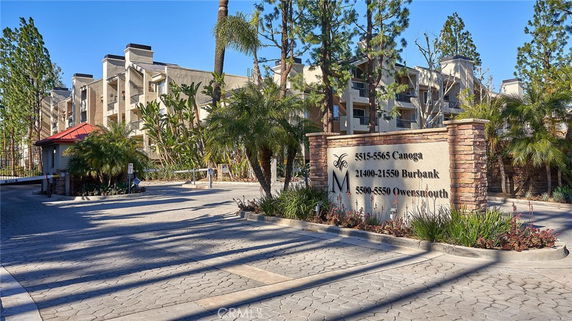 Front view of a multi-story residential building complex with a gated entrance.