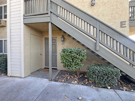 Front view of a building entrance with stairs leading to the upper floor.
