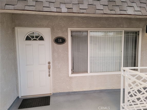 Front view of a building entrance with a white door and window.