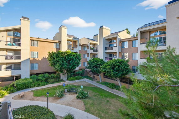 Front view of a multi-story apartment building with balconies.