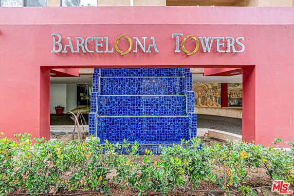 Front view of Barcelona Towers with a blue tiled water feature.