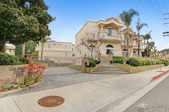 Front view of a multi-story residential building with a gated entrance.