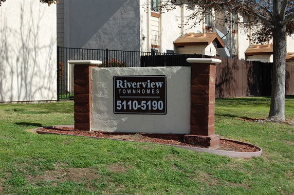 Front view of townhomes with a sign reading 'Riverview Townhomes 5110-5190'.