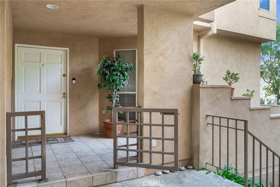 Front view of a building entrance with a white door and potted plants.