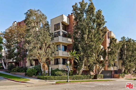 Front view of a multi-story building with trees surrounding it.