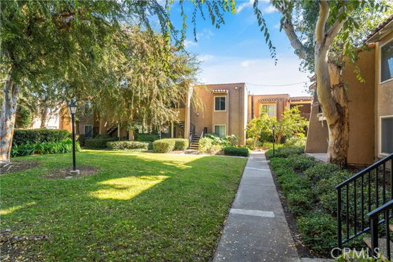 Front view of a residential building with trees and a walkway.