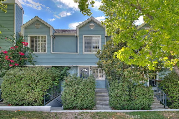 Front view of a two-story house with blue siding and multiple windows.